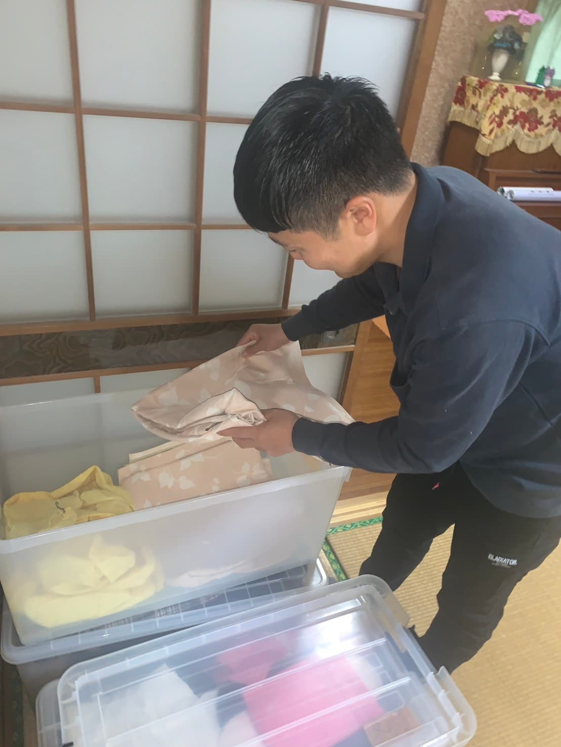 明るいリビングでシニア女性が笑顔でアルバムを眺めている写真
